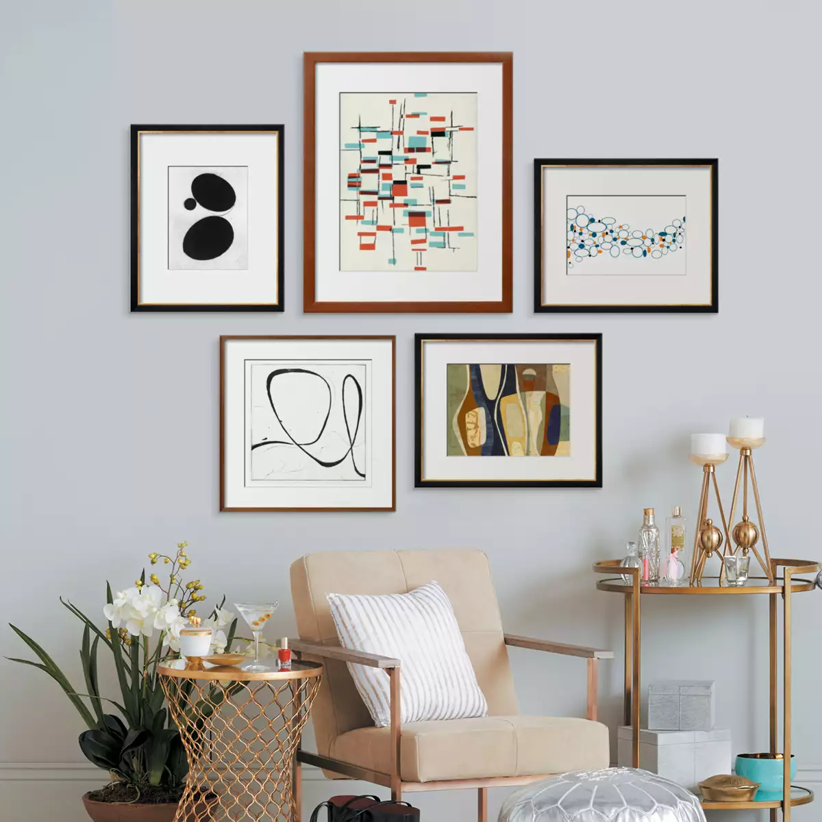 five photo frames in a grey colored wall with a chair & other things on its bottom